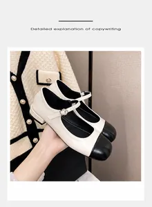 Detail of two-tone Mary Jane shoe featuring a black toe cap and rhinestone buckle strap