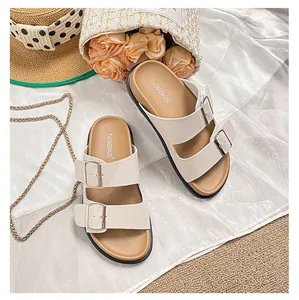 Close-up of beige platform sandals with double metal buckles and pebbled texture