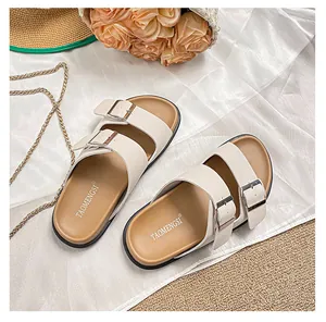 Detail of ergonomic cork footbed and adjustable buckles on women's beige slides