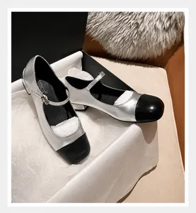 Detail of silver Mary Jane flat with black round toe and slim buckle strap