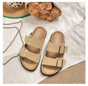 Detailed top view of beige buckle slide sandals with elegant straw hat and floral accents