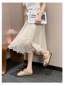 Close-up of beige double-strap flat sandals with metal buckles in a cozy lifestyle setting