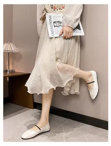 Vue détaillée de ballerines Mary Jane blanches avec fines brides noires et jupe