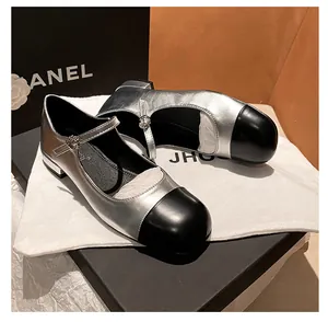 Detail view of silver and black leather Mary Jane flats with buckle strap and packaging