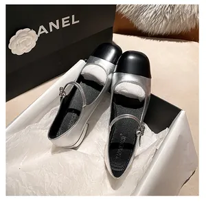 Detail of silver and black Mary Jane shoes with pearl buckle and round cap toe design