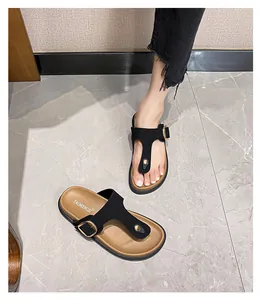 Detail showing genuine leather thong sandals with gold buckle on a thick cork sole