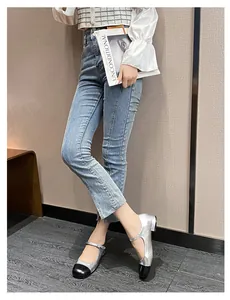 Silver and black contrast toe Mary Jane flat shoes paired with slim fit blue jeans