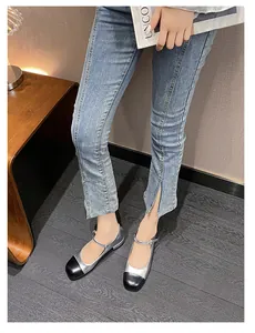Silver Mary Jane flats with black cap toe on model showing the metallic leather texture
