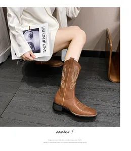 Primer plano de botas cowboy marrones con bordado blanco y tacón grueso efecto madera