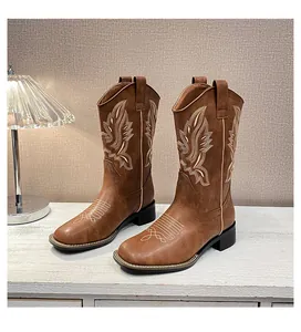 Detalle de bordado y textura en botines western marrones con punta cuadrada y tacón