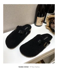 Detail of black faux fur mule slippers with leather strap and golden metal buckle