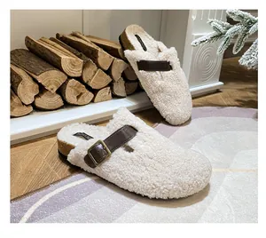 Detail view of cream sherpa clogs with cork sole and retro brown buckle strap decoration