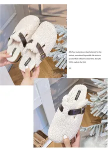 Detail of plush white wool slippers with adjustable brown leather straps and metal buckles