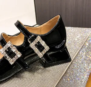 Detail von schwarzen Lackleder Mary Janes mit großer Kristallschnalle und 3 cm Blockabsatz