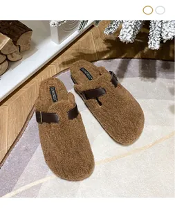 Close-up of brown plush Birkenstock clogs with faux sheepskin and leather buckle detail