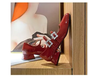 Detailansicht roter Lack-Mary-Janes mit quadratischen Strass-Schnallen und stabilen Blockabsätzen