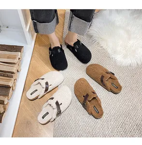 Close-up of cozy faux fur clogs in black, beige and brown with leather buckle straps