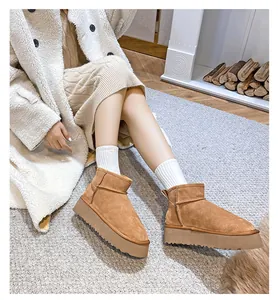 Close-up of brown suede platform snow boots with warm faux fur lining and thick soles