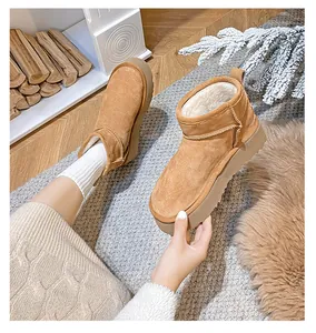 Close-up of chestnut suede platform snow boots with thick white faux fur lining inside