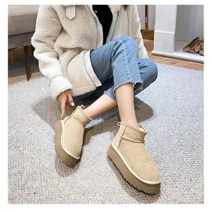 Detailed close-up of camel suede platform snow boots with thick serrated soles for winter