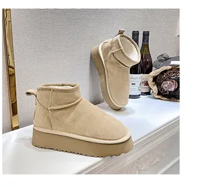 Detail view of beige suede mini snow boots with thick platform and warm fleece lining