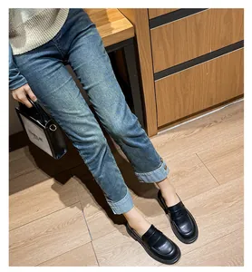 Mocasines clásicos de cuero negro para mujer mostrados sobre un suelo de madera