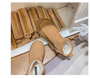 Detailed view of brown suede snow boots with thick white faux fur lining and heel pull tab