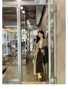 Winter outfit featuring a long wool coat and platform snow boots in a minimalist style
