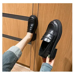 Detalle de mocasines negros de plataforma en cuero sintético mate con tira clásica