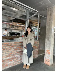 Street style view of a beige long wool coat with large lapels and oversized winter fit