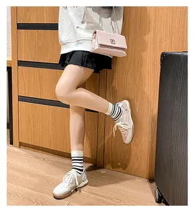 Beige leather low-top sneakers paired with striped socks and a pink handbag set
