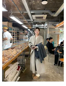 Chic beige wool coat and platform snow boots styled in a warm cafe lifestyle setting