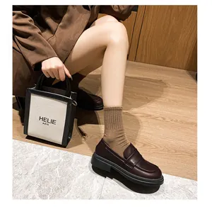 Mocasines con plataforma de estilo británico en cuero marrón oscuro y calcetines