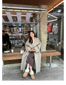French street style view of model in wool coat and plush camel snow boots