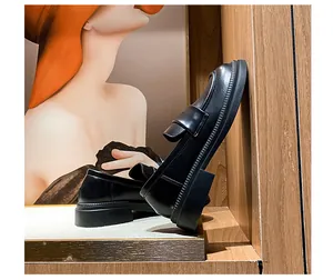 Detalle de mocasines negros con plataforma que muestran el cuero mate y la suela gruesa