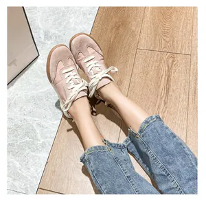 Overhead view of pink leather ballet sneakers with brown rubber soles and blue jeans