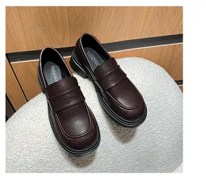 Detalle de mocasines de cuero marrón oscuro con grabado de estrellas y suelas de plataforma