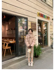 Outdoor street view of a beige short puffer jacket with a cozy scarf and warm snow boots