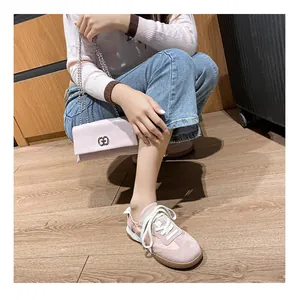 Detail showing pink leather sneakers with brown rubber sole and matching chain bag