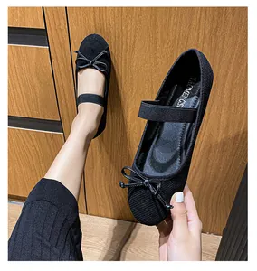 Dettaglio di ballerine Mary Jane nere con fiocco e cinturino elastico su tessuto strutturato