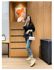 Mirror selfie showing a woman wearing a black double-breasted blazer with blue jeans