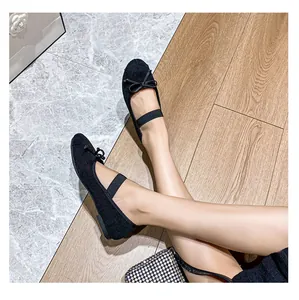Dettaglio di ballerine Mary Jane nere con cinturino elastico e fiocco indossate dal modello