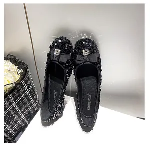 Dettaglio delle ballerine in paillettes nere con fiocco e strass lettera B