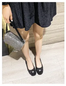 Dettaglio ballerine nere con paillettes e fiocco abbinate a borsa in strass argento