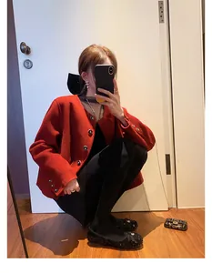Dettaglio della giacca in tweed rosso con bottoni metallici e scollatura rotonda