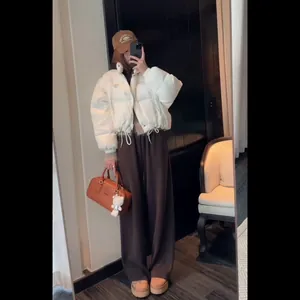 Women's white puffer jacket and brown wide-leg pants with stylish winter accessories
