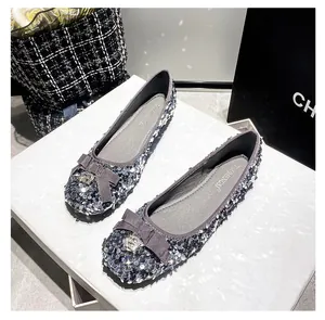 Dettaglio di ballerine con paillettes argento e fiocco di strass su sfondo neutro