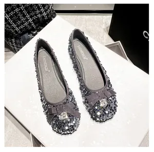 Dettaglio di ballerine con paillettes argento con fiocco e fibbia di strass