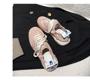 Detailed top view of pink leather Gump sneakers on a stylish black jacket background
