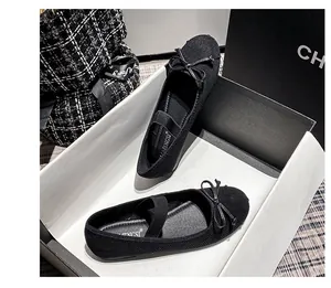 Dettaglio delle ballerine Mary Jane nere con cinturini elastici e fiocco decorativo